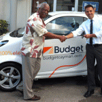 John Felder, left, hands over the keys to Cayman's first electric rental car to Brian Krug of Budget.